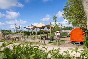 ヴェストカペレにあるHello Zeeland - Tiny House Zeeuwse Liefde 16のテントとオレンジ色の構造物がある遊び場