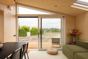 ヴェストカペレにあるHello Zeeland - Tiny House Zeeuwse Liefde 16のリビングルーム(大きなスライド式ガラスドア付)
