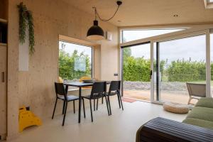 ヴェストカペレにあるHello Zeeland - Tiny House Zeeuwse Liefde 16のテーブルと椅子のあるダイニングルームとリビングルーム +24枚の写真
