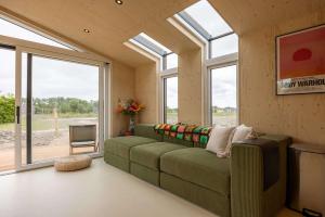 ヴェストカペレにあるHello Zeeland - Tiny House Zeeuwse Liefde 16のリビングルーム(緑のソファ、窓付)