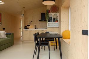 una piccola cucina e sala da pranzo con tavolo e sedie di Hello Zeeland - Tiny House Zeeuwse Liefde 16 a Westkapelle