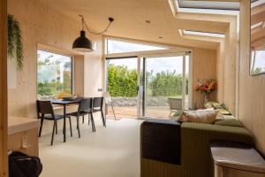 un soggiorno e una sala da pranzo con divano e tavolo di Hello Zeeland - Tiny House Zeeuwse Liefde 16 a Westkapelle