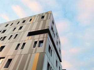 een hoog gebouw tegen een blauwe lucht bij Auberge de jeunesse HI Clermont-Ferrand in Clermont-Ferrand