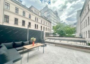 布达佩斯TubLife Terrace Suite II PRIVATE JACUZZI II freeparking的带沙发、桌子和建筑物的露台