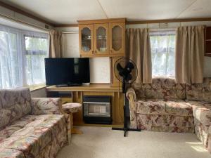 a living room with a couch and a flat screen tv at Guest house PURINI in Jūrmala