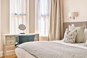a bedroom with a bed and a desk with a mirror at Number 5 in Margate