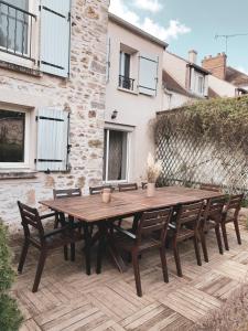 a wooden table and chairs on a patio at La Maison Gabriac in Boissise-la-Bertrand +52 photos