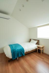 a bedroom with a bed and a window at MOVA VILLA Koshi Misawa 2 in Yuge