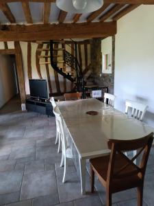 a dining room with a white table and chairs at Maison de Charme en Normandie in Conteville +8 photos
