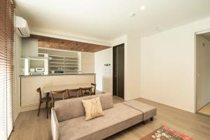 a living room with a couch and a table in a kitchen at Mova Villa Koshi 三澤 2 - 新築一軒家貸切 無料駐車場付 ファミリー向け キッズフレンドリーな宿 in Yuge