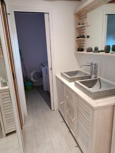 a white bathroom with a sink and a toilet at Maison de Charme en Normandie in Conteville