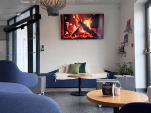 een woonkamer met een bank en een open haard aan de muur bij Auberge de jeunesse HI Clermont-Ferrand in Clermont-Ferrand