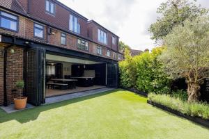 un patio interior de una casa con césped en Veeve - The Garden Home, en Londres