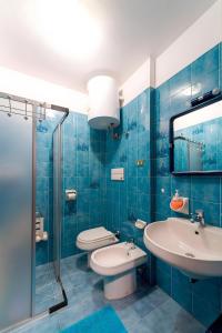 a blue bathroom with a toilet and a sink at Appartamento Pineta in Chiesa in Valmalenco
