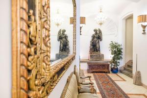 a mirror in the hallway of a home with a chair at Charles Bridge Palace in Prague