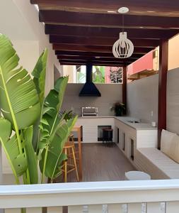 an open kitchen and living room with a potted plant at Adorável Casa em Cond. de frente para a Praia Rasa in Búzios
