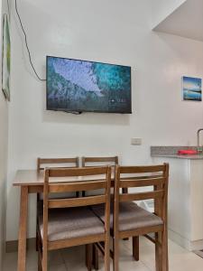 two chairs and a table with a television on a wall at Wind Residences Cool suites 1BR unli Wifi, PrimeVideo, Nice pool, Near Malls in Kaybagal +37 photos