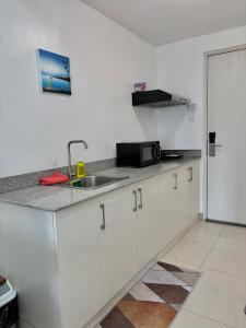 a kitchen with a sink and a counter top at Wind Residences Cool suites 1BR unli Wifi, PrimeVideo, Nice pool, Near Malls in Kaybagal