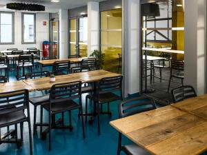 een eetkamer met houten tafels en stoelen bij Auberge de jeunesse HI Clermont-Ferrand in Clermont-Ferrand