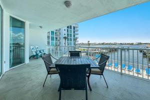 a table and chairs on a balcony with a view of the water at The Pass Unit 207 in Orange Beach