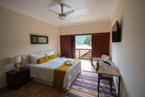 a bedroom with a bed and a sliding glass door at Pousada Costa Rielli in Águas de Lindoia