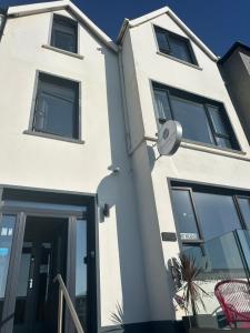 a white building with black windows and a door at Causeway Bay Guesthouse Portrush in Portrush +22 photos