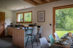 a kitchen with a counter and chairs and a table at Chalet Ormiages - OVO Network in Saint-Gervais-les-Bains