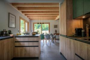 a kitchen with wooden cabinets and a dining room at Chalet Ormiages - OVO Network in Saint-Gervais-les-Bains
