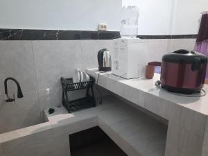 a kitchen with a counter top with a appliance on it at Ayunda Stay & Hostel in Airsatang