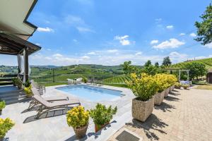 a house with a swimming pool and a patio at Villa Edy Barbaresco con piscina per gruppi e famiglie in Barbaresco