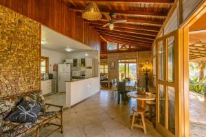 an open kitchen and living room with a stone wall at Chácara Temporada Lazer Piscina Amparo Net 200 Mb! in Amparo