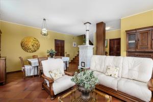 salon z białą kanapą i kominkiem w obiekcie Villa Edy Barbaresco con piscina per gruppi e famiglie w mieście Barbaresco