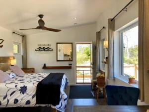 Un dormitorio con una cama y un ventilador de techo. en The Snuggy - NEW! Oceanview - Private - Eco-Lux - King Bed - Adults Only!, en Ingonish