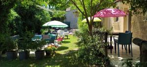 a garden with tables and chairs and umbrellas at Abrivado in Aimargues
