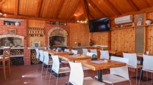 a dining room with wooden tables and white chairs at Dvůr Stupice in Stupice