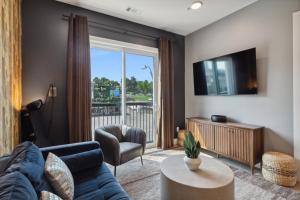 a living room with a couch and a tv at Rhinestone Cowboy in East Nashville, 5 minutes to Downtown and Broadway in Nashville