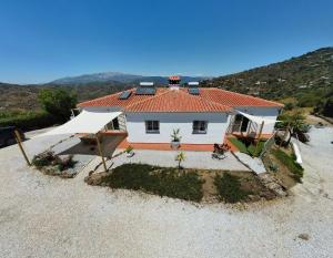 a white house with a red roof on a beach at Sobremesa Boutique in Caserío Carraspite