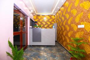 a man standing at a counter in a room with a yellow wall at Hotel Ayodhya Palace - 400 Mtrs from HANUMAN GARHI in Ayodhya