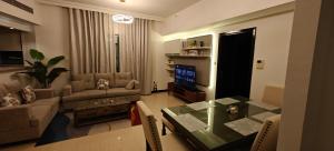a living room with a couch and a table and a television at JLT 1BR Marina Skyline View in Dubai