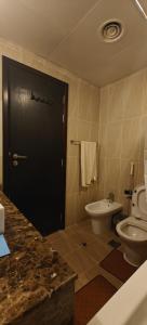 a bathroom with a toilet and a black door at JLT 1BR Marina Skyline View in Dubai