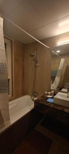 a bathroom with a tub and a sink and a bath tub at JLT 1BR Marina Skyline View in Dubai