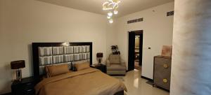 a bedroom with a bed and a chair at JLT 1BR Marina Skyline View in Dubai