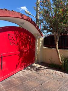 a red garage door with a tree and a fence at B&B La morada de Barbara in Taranto +17 photos