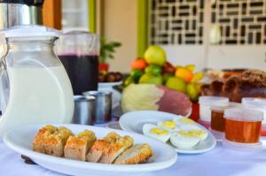 a table with plates of food and eggs on it at Hospedaria Bom Pastor in Nova Petrópolis