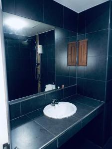 ein Badezimmer mit Waschbecken und Spiegel in der Unterkunft Green Terrace Residence Phuket in Kathu