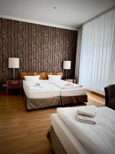 a hotel room with two beds and two lamps at Erlanger Hof in Berlin
