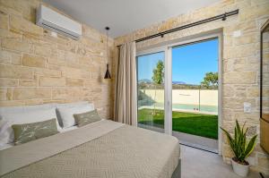Un dormitorio con una cama y una ventana grande. en Avgi, en Pitsidia 73 fotos más