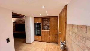 cocina grande con armarios de madera y pared de ladrillo en Oldtown Guesthouse Cologne I 100qm I 10m from Rhine, en Colonia 8 fotos más