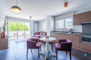 a kitchen and living room with a table and chairs at Tempologis Grenoble in Grenoble