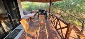 a balcony with a table and chairs and a laptop at The South Post @ Kruger in Marloth Park